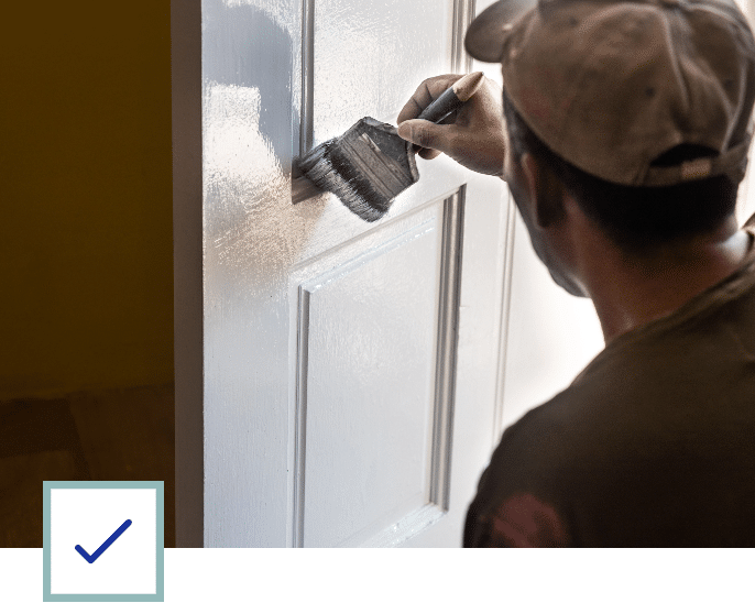 Maintenance Employee Painting a Door